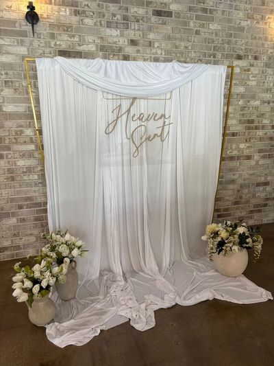 Heaven Sent baby shower draped backdrop with floral arrangements