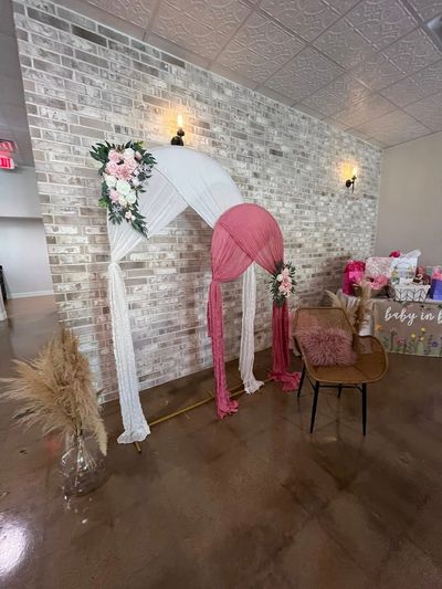 Pink umbrella baby shower backdrop with pampas grass
