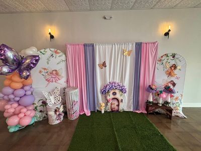 Fairy and butterfly themed birthday backdrop with pastel balloons