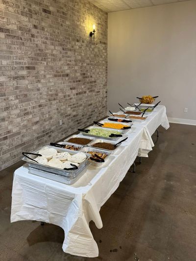 Buffet table with chafing dishes along the brick wall