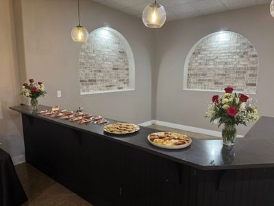 Dessert bar with cupcakes and roses beneath the brick arches