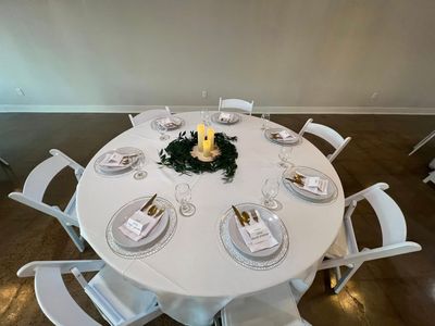 Elegant round table with candle, greenery, and full place settings