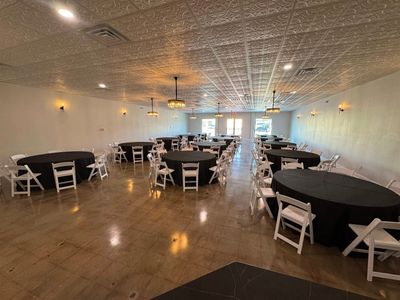 Wide view of the ballroom with black linen round tables