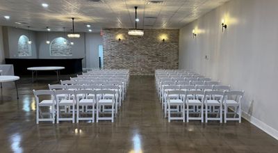 Ceremony seating arranged in rows of white chairs