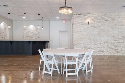 Round table beside the bar with white brick wall and pendant lighting