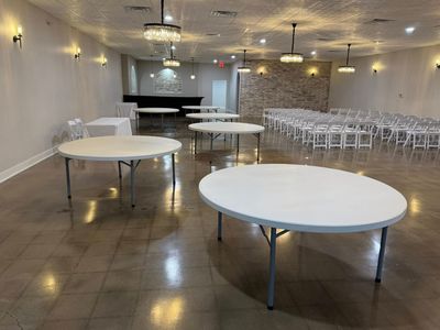Round tables and ceremony chairs being arranged in the ballroom