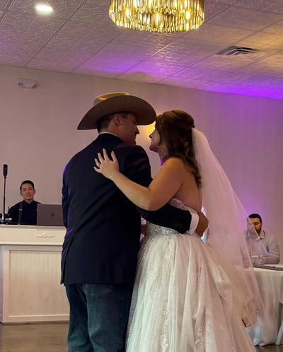Bride and groom share a first dance under the chandelier