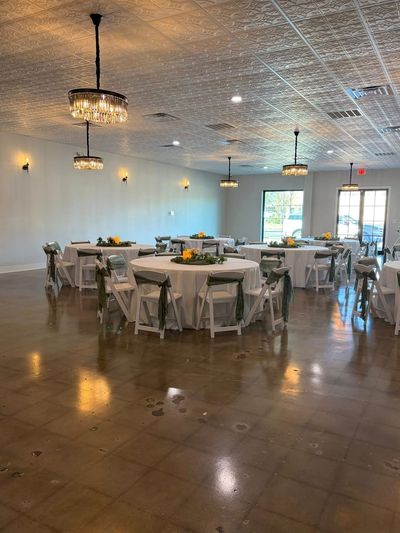 Wedding reception ballroom with round tables and greenery centerpieces