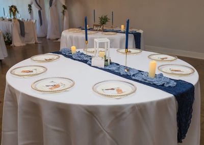 Sweetheart table with a navy runner and gold-rimmed plates